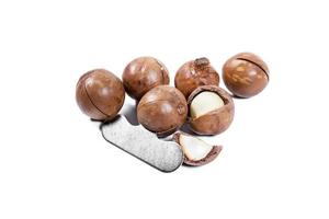 Open Macadamia nut by tool on background photo