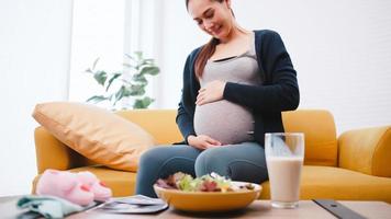 mujer embarazada feliz come alimentos saludables para su bebé por nacer. foto