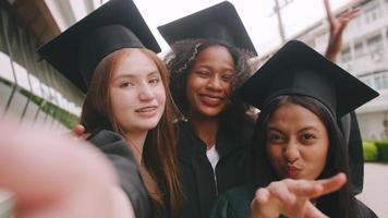 grupo de amigos divirtiéndose celebrando su graduación tomando fotos juntos.