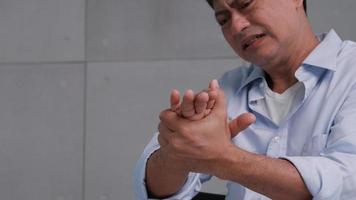 un hombre asiático tiene hormigueo y entumecimiento en la mano que causa beriberi. foto