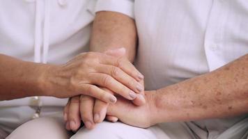 Close up of eldery couple holding hands together. photo