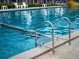 Escaleras de acero inoxidable a la piscina. Pasamanos arriba y abajo de la piscina. foto