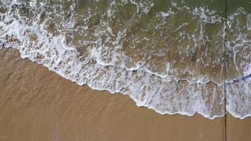 schöne meereswellen und weißer sandstrand auf der tropischen insel. sanfte wellen des blauen ozeans auf sandstrandhintergrund von der draufsicht von drohnen. konzept der entspannung und reise in den urlaub. video