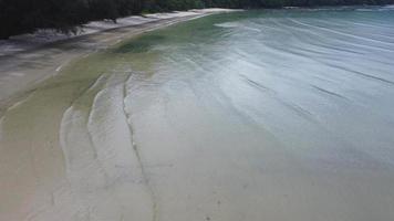 skön hav vågor och vit sand strand i de tropisk ö. mjuk vågor av blå hav på sandig strand bakgrund från topp se från drönare. begrepp av avslappning och resa på semester. video