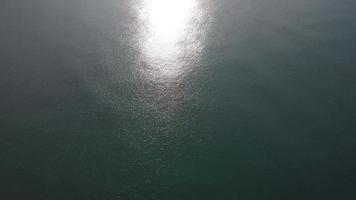 Aerial view from the drone of the sea. Background of sea surface with sunlight reflecting on water surface. blue sea background in tropical sea video