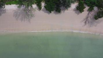 skön hav vågor och vit sand strand i de tropisk ö. mjuk vågor av blå hav på sandig strand bakgrund från topp se från drönare. begrepp av avslappning och resa på semester. video