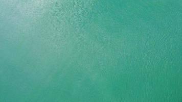 Aerial view from a drone of the Andaman Sea. Background of sea waves with sunlight reflected on the water surface. blue sea background in tropical sea. video