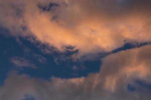 paisaje de nubes. nubes de cúmulos de verano rosas y marrones en un cielo azul durante la puesta de sol. fondo de pantalla. antecedentes. foto