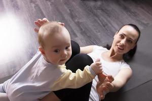 The child plays, does exercises, does gymnastics with his mother at home. photo