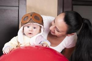 niño aviador, con sombrero de piloto, junto con una hermosa madre joven, retrato de cerca. foto