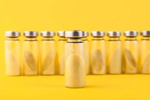 Bubbles, ampoules with dry probiotic, bifidobacteria, with probiotic powder inside on a yellow background. Copy space. photo
