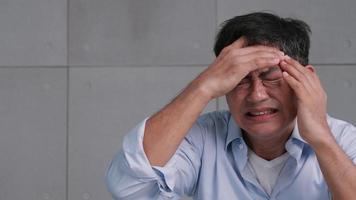 Asian old man with migraine headache. Man feel stressed and worried about health problems. photo