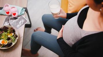 mujer embarazada feliz come alimentos saludables para su bebé por nacer. foto