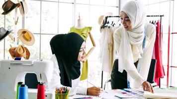 Beautiful muslim women sketching clothes silhouette together at the office. photo