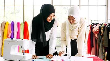 Beautiful muslim women working together at the clothing office. photo