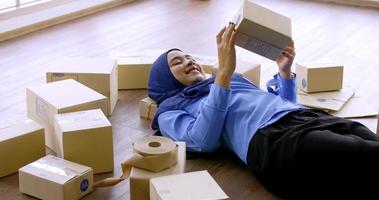 Happy muslim merchandiser woman holding parcel box in the office. photo
