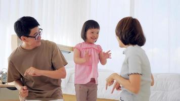 Happy family with mother, father and disabled daughter spending time together in bedroom. photo