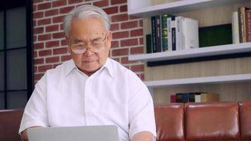 Eldery man using laptop computer at home. photo