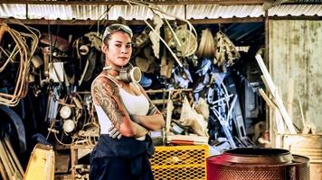 Atractiva joven trabajadora mecánica reparando un auto antiguo en un viejo garaje foto