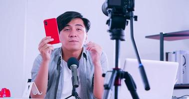 Young asian man selling digital gadgets on social media by streaming live from his home. photo