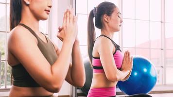 dos chicas asiáticas haciendo ejercicios de yoga en casa. foto