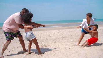 familia divirtiéndose jugando juntos en la playa. foto