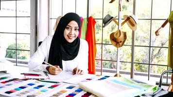 Beautiful muslim woman sketching clothes silhouette at the office. photo