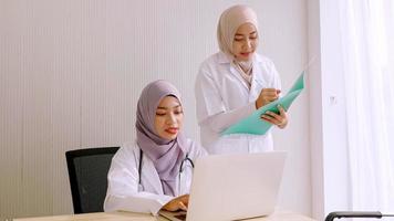 Muslim female doctor and medical assistants working together at hospital room. photo