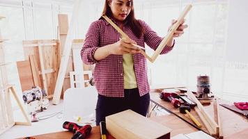 carpintero femenino colocando piezas de tableros en el sitio. foto