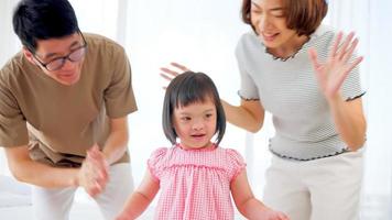 Happy family with mother, father and disabled daughter spending time together at home. photo