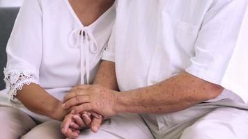 Close up of eldery couple holding hands together. photo