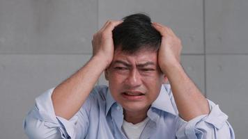 Asian old man with migraine headache. Man feel stressed and worried about health problems. photo