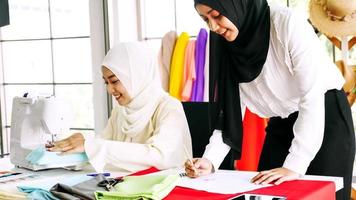 Beautiful muslim women sketching clothes silhouette together at the office. photo