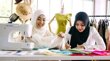 Happy muslim women working together at the clothing office. photo