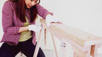 Female carpenter fitting pieces of boards together at site. photo