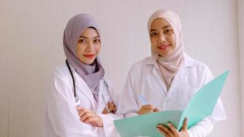 Muslim female doctor and medical assistants standing together at hospital room. photo