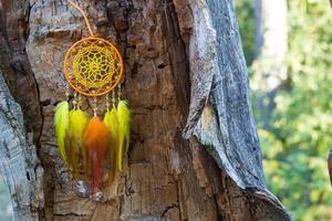 atrapasueños hecho a mano con hilos de plumas y cuerda de cuentas colgando foto