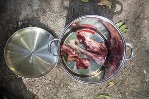 raw mutton bones for cooking soup in a pot in nature photo