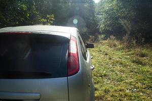 Shiny car with silver paint. Water drops on the hood. photo