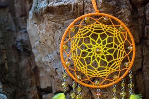 atrapasueños hecho a mano con hilos de plumas y cuerda de cuentas colgando foto