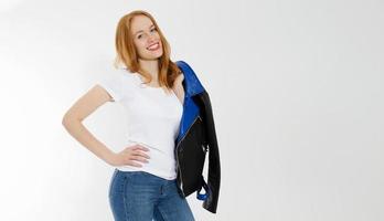 Woman in white t shirt and black leather jacket isolated on white background. Red hair girl in fashion clothes front view. Blank template summer t-shirt. Copy space photo