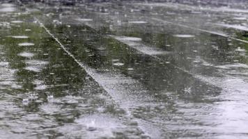 les gouttes de pluie frappent sur le toit, fortes pluies, averses. le toit plat du bâtiment est recouvert d'un matériau imperméable qui protège de la pluie. ruberoïde, toiture enroulée et matériau d'étanchéité. video