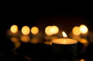 Many candles burn with a shallow depth of field. photo