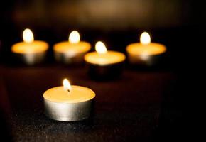 three burning candles on black background photo