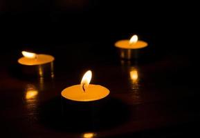 three burning candles on black background photo