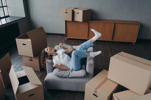 Overjoyed spanish young woman has bought a new apartment. Lady is relaxing in armchair. photo