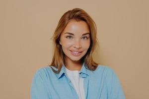 Headshot portrait of happy brunette model female in blue shirt photo