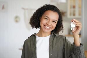 Face of african american girl which is holding key from new apartment. Home owner is relocating. photo