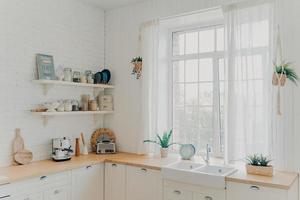 Domestic family kitchen. Brightly lit scandinavian kitchen interior with window. Modern apartment. photo