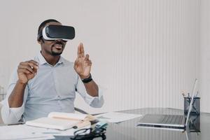 desarrollador de ingeniero de ti afroamericano en gafas vr trabajando con realidad virtual en el escritorio de la oficina foto